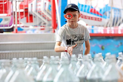 12082026
Weston Apperley tries his luck at the ring toss game during Midway Madness in the Canadian Tire parking lot in Brandon’s south end on Wednesday afternoon. The four day fair began on Monday and ends today. (Tim Smith/The Brandon Sun)