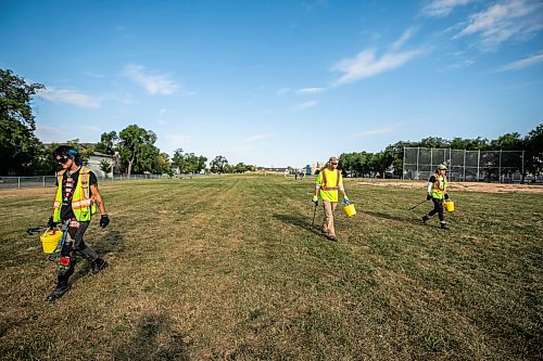MIKAELA MACKENZIE / FREE PRESS
	
City crew members Alex Cloney (left), Kyle Bergantim and Tee Silver clean up needles and other hazardous materials at Freight House park on Thursday, Aug. 13, 2026.

For Malak story.
Free Press 2026