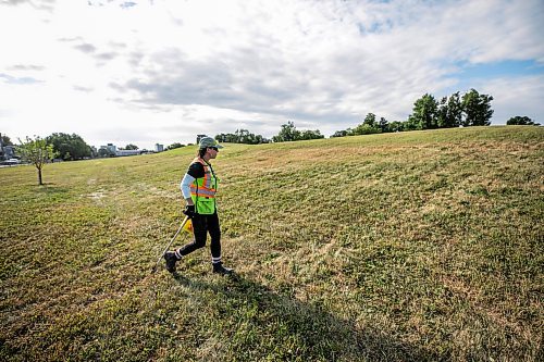 MIKAELA MACKENZIE / FREE PRESS
	
City crew member Tee Silver checks for needles and other hazardous materials at Freight House park on Thursday, Aug. 13, 2026.

For Malak story.
Free Press 2026