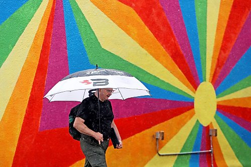 14082026
An umbrella-wielding pedestrian passes by a mural in downtown Brandon on a rainy Friday.
(Tim Smith/The Brandon Sun)