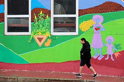 14082026
A pedestrian passes by a mural on the side of Samaritan House Ministries in downtown Brandon on a rainy Friday.
(Tim Smith/The Brandon Sun)
