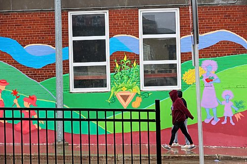 14082026
Pedestrians pass by a mural on the side of Samaritan House Ministries in downtown Brandon on a rainy Friday. 
(Tim Smith/The Brandon Sun)