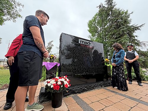 MORGAN MODJESKI/FREE PRESS
Chris Anderson and his wife Rachael, look on at MADD Canada's Manitoba Memorial which now carries his brother Robbie Anderson's name at the Glen Eden Funeral Home and Cemetery in West St. Paul, Man. on Aug. 15, 2026. Its placement is alongside the names of 85 other innocent victims who died as a result of drunk or drug-related impaired driving. Joined by officials from the province and the law enforcement, he said he's grateful for the support and the work MADD does.