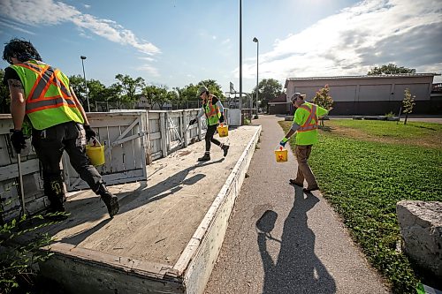 MIKAELA MACKENZIE / FREE PRESS
City crew members Alex Cloney (left), Tee Silver and Kyle Bergantim clean up needles and other hazardous materials at Freight House park on Thursday, Aug. 13, 2026.
For Malak story.
Free Press 2026