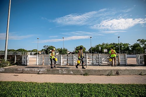 MIKAELA MACKENZIE / FREE PRESS
	
City crew members Tee Silver (left), Alex Cloney and Kyle Bergantim clean up needles and other hazardous materials at Freight House park on Thursday, Aug. 13, 2026.

For Malak story.
Free Press 2026