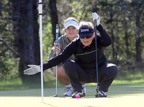 Christine Curtis reads the seventh green for her daughter Hailey Clark during Tamarack golf tournament ladies scramble qualifying at Clear Lake Golf Course on Monday. (Thomas Friesen/The Brandon Sun)