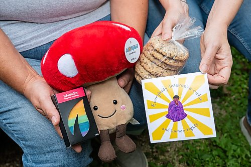 ROBERT LEE / FREE PRESS
Kalyn Falk, right, and project partner Lindsay Unger display some of the items that are included in a care package in Winnipeg on Monday, August 17, 2026. The pair help lead the TDOR Care Package Project, launched in 2020 to honour Trans Day of Remembrance by preparing about 50 care packages so trans and non-binary community members feel valued, seen and cared for. This year, the project is partnering with Resource Assistance for Youth, which will accept donations and issue charitable tax receipts ahead of the Nov. 20 day of remembrance.