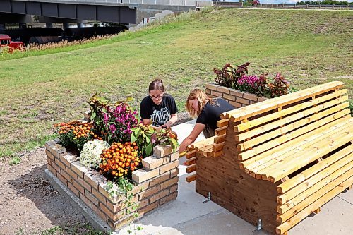 17082026
Architecture student Rebecca Grant and landscape architecture student Anastasia Zonenberg, both with the University of Manitoba, install a bench as part of their Downtown Outdoor Art Grant creation Station Bloom along Pacific Avenue in Brandon just west of First Street on Monday. The fourth year architecture students applied for the grant earlier this year and their project was chosen as one of several successful downtown arts projects being created this summer. The project is funded by the City of Brandon, Brandon Downtown BIZ and the Brandon Area Community Foundation. The bench and adjacent planters are meant to vaguely resemble the look of a train, as homage to the train yard directly behind the site of the installation. The brick flower bed on the left side of the bench also slopes, pointing towards Brandon’s downtown business district.
(Tim Smith/The Brandon Sun)