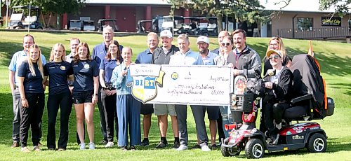 An assembly of Brandon University Athletics staff, athletes and charity executives standing around the $85,000 cheque (Rowan McCarthy/Brandon Sun).