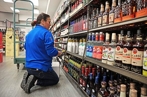 Roberta Rosen with the Manitoba Liquor Mart on 10th Street and Victoria Avenue in Brandon helps stock U.S. liquor onto shelves at the retailer last December. (Tim Smith/The Brandon Sun files)