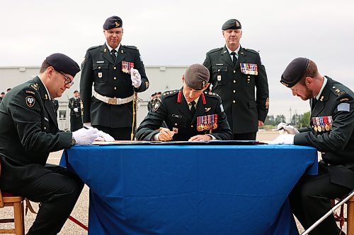 Knox, Commander Michael Reekie with the 1st Canadian Mechanized Brigade Group and outgoing 1RCHA commanding officer Lt.-Col. Jordan Beatty sign scrolls for the official change of command. (Tim Smith/The Brandon Sun)