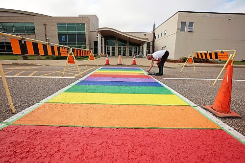 20082026
Max Bratzke, roads and grounds supervisor for CFB Shilo, paints the crosswalk just outside the General Strange Hall in the vibrant colours of the Pride flag on Thursday. The base originally painted the crosswalk on Royal Avenue in the Pride colours in 2022 to recognize the achievements and contributions of LGBTQ2+ military members. Because Royal Avenue is undergoing extensive road work, the new Pride crosswalk was painted. 
(Tim Smith/The Brandon Sun)