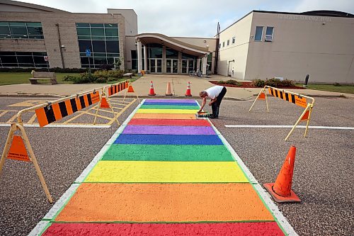 20082026
Max Bratzke, roads and grounds supervisor for CFB Shilo, paints the crosswalk just outside the General Strange Hall in the vibrant colours of the Pride flag on Thursday. The base originally painted the crosswalk on Royal Avenue in the Pride colours in 2022 to recognize the achievements and contributions of LGBTQ2+ military members. Because Royal Avenue is undergoing extensive road work, the new Pride crosswalk was painted. 
(Tim Smith/The Brandon Sun)