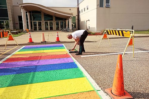 20082026
Max Bratzke, roads and grounds supervisor for CFB Shilo, paints the crosswalk just outside the General Strange Hall in the vibrant colours of the Pride flag on Thursday. The base originally painted the crosswalk on Royal Avenue in the Pride colours in 2022 to recognize the achievements and contributions of LGBTQ2+ military members. Because Royal Avenue is undergoing extensive road work, the new Pride crosswalk was painted.
(Tim Smith/The Brandon Sun)