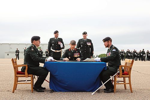 20082026
Incoming 1st Regiment, Royal Canadian Horse Artillery Commanding Officer Lieutenant-Colonel Patrick Knox, Commander Michael Reekie with the 1st Canadian Mechanized Brigade Group, and outgoing 1 RCHA Commanding Officer Lieutenant-Colonel Jordan Beatty sign scrolls for the official change of command during the 1 RCHA change of command ceremony at CFB Shilo on Thursday. 
(Tim Smith/The Brandon Sun)