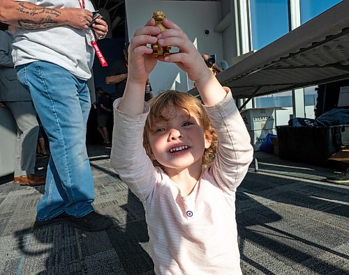 ROBERT LEE / FREE PRESS
Vivienne Verbeek, 2, plays with a figurine of the Burmese lion, known as a chinthe, at the reception for the iconic CC-130H Hercules that is standing down from service at the Royal Aviation Museum in Winnipeg on Friday, August 21, 2026. Vivienne is the daughter of Tim Verbeek, Trainee pilot of the 435 Squadron.