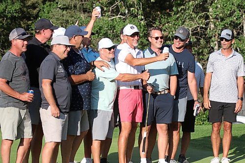 Jason Thorpe, centre, poses for a photo with friends on the 16th green. (Thomas Friesen/The Brandon Sun)
