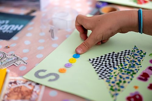 ROBERT LEE / FREE PRESS
Stella Birnie works on her collage at Scrap &amp; Yap, an arts-and-crafts collage group that has been setting up a table at the Riverview market on Monday, August 24, 2026. 