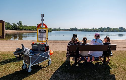 MIKE DEAL / FREE PRESS
The Pipes family sits on a bench near warning signs on the beach because of high e. coli levels in the water in St. Malo Provincial Park.
Reporter: Melissa Martin
260821 - Friday, August 21, 2026.