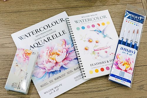 MIKE DEAL / FREE PRESS
Some of the products that Willow markets, including a collaboration with Winsor and Newton Cotman watercolour set, a pad of 100% cotton watercolour paper, a Willow Wolfe watercolour painting workbook and a set of Willow Wolfe amavi brushes.
Willow Wolfe has been in the art supplies business for over 30 years. Her mother and her opened a store on Grant when she was 20; she now runs a company that markets her personal line of paint brushes to 450 retailers, all over the world. Additionally, Willow publishes art-training books developed by her and her daughter, and conducts how-to lessons for new and veteran artists, either in person or via videos recorded in her home studio.
Reporter: Dave Sanderson
260826 - Wednesday, August 26, 2026.