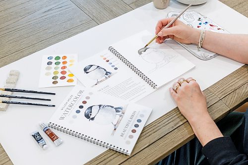 MIKE DEAL / FREE PRESS
Willow Wolfe with one of her watercolour art-training books.
Willow Wolfe has been in the art supplies business for over 30 years. Her mother and her opened a store on Grant when she was 20; she now runs a company that markets her personal line of paint brushes to 450 retailers, all over the world. Additionally, Willow publishes art-training books developed by her and her daughter, and conducts how-to lessons for new and veteran artists, either in person or via videos recorded in her home studio.
Reporter: Dave Sanderson
260826 - Wednesday, August 26, 2026.