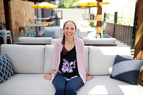 Erin Wells, manager of The Dock on Princess, sits on one of the couches in the pub and restaurant’s new patio area on Friday. (Tim Smith/The Brandon Sun)