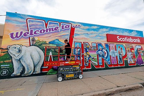 MIKE DEAL / FREE PRESS
Artist Jennifer Mosienko moves a scissor lift by the Welcome to Winnipeg mural she painted on the side of the Scotia Bank at 3247 Portage Avenue.
Reporter: standup
260828 - Friday, August 28, 2026.