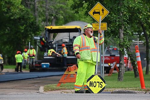Construction flagger Todd Bone shares a laugh with a co-worker while on the job at the corner of 18th Street and Louise Avenue. Bone is part of a construction crew that is in the process of repaving Louise Avenue this week. (Matt Goerzen/The Brandon Sun)