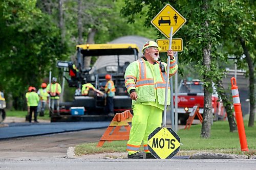 Construction flagger Todd Bone shares a laugh with a co-worker while on the job at the corner of 18th Street and Louise Avenue. Bone is part of a construction crew that is in the process of repaving Louise Avenue this week. (Matt Goerzen/The Brandon Sun)