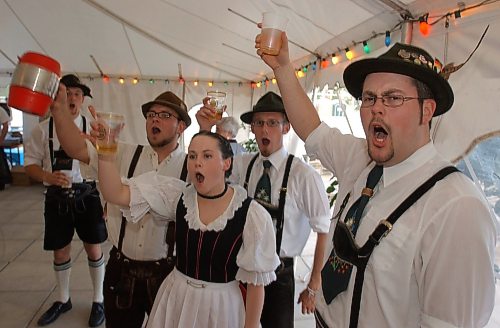 Legacy Brandon Sun COLIN CORNEAU/BRANDON SUN  Richard Russell (right) and other festively garbed fans of Sommerfest salute in a German toast, Friday evening at the South End Community Centre. The Teutonically-themed party continues tonight with music, food, drink and fun.