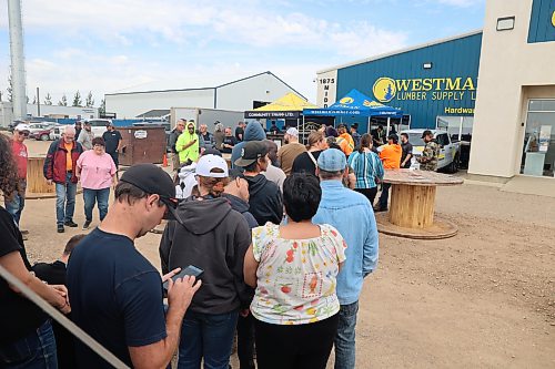 Westman Lumber Supply customers join the line to grab food and take part in the company's 10th year anniversary on Friday afternoon. (Abiola Odutola/The Brandon Sun)