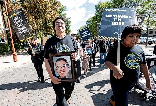 JOHN WOODS / FREE PRESS
Dr Stewart Hill holds a photo of his son as he and other people participate in the Fentanyl Awareness Day Walk from the Forks to the legislature Sunday, September 13, 2026.
reporter: marsha