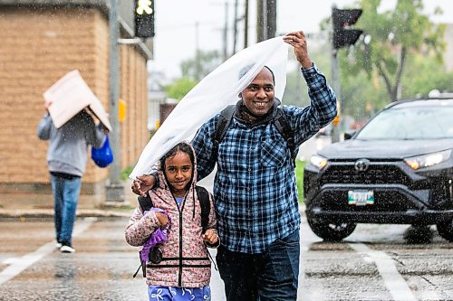 MIKAELA MACKENZIE / FREE PRESS
Mahedi Al Mamun and his daughter, Afia Ibnat Muniba (seven), use a makeshift piece of plastic to cover their heads while walking through the rain downtown at Notre Dame and Carlton on Monday, Sept. 14, 2026.
Standup.
Free Press 2026