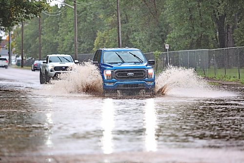 A truck sprays water at a flooded intersection on 13th Street, just in front of the Brandon Fire Station 2 after a morning of rain on Monday. (Matt Goerzen/The Brandon Sun)