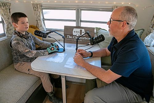 BROOK JONES/FREE PRESS
David Balzer, 60, has converted his Triple E Surfside camper trailer called Chatter Box into a mobile recording studio in which he records people's stories of gratitude and belonging. The associate professor of communications and media at Canadian Mennonite University was at the Elim Mennonite Church in Grunthal, Man., to record stories from varous church members on Sunday, Sept. 13, 2026. Pictured: Chatterbox producer David Balzer (right) interviews Christoph Reimer, 11, who is from Kleefeld, Man.,