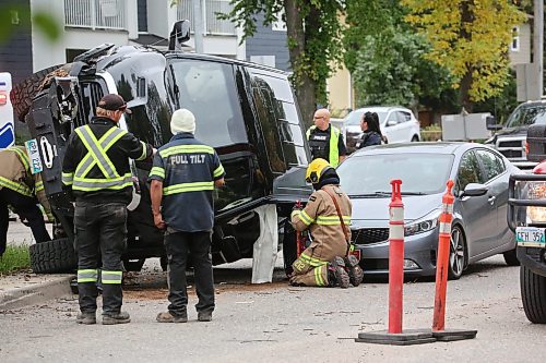 A crew with Brandon Fire and Emergence Services work on a black truck that hit a tree on the median at the corner of Victoria Avenue and Second street and flipped shortly after 1 p.m. on Wednesday, coming to rest on its side, and balanced on the hood of a four-door sedan that was driving behind. The driver of the truck had to be pulled from the vehicle and was placed on a stretcher before being taken to hospital. (Matt Goerzen/The Brandon Sun)