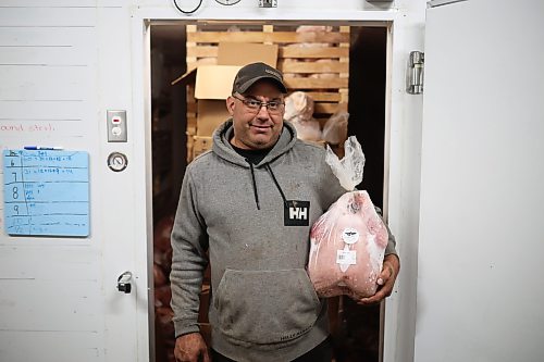 18092026
Brian Blanchard with Evergreen Alley Farms south of Boissevain with a frozen turkey for sale in front of the freezer at his farm on Friday. Blanchard and his partner Alicia Dyck raised 100 turkeys this year for sale. (Tim Smith/The Brandon Sun)