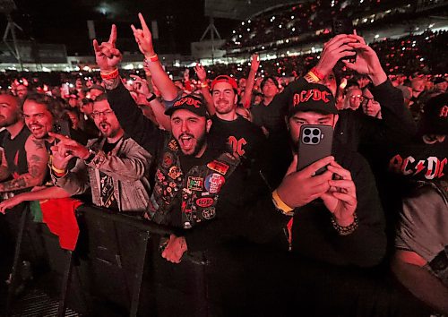 Jason Halstead / Free Press
Hardcore AC/DC fans Mark Cacciatore (centre left) and Hugo Bernier (with phone) — both from France — cheer AC/DC at Princess Auto Stadium in Winnipeg on Sept. 20, 2026 after following the band across Canada.