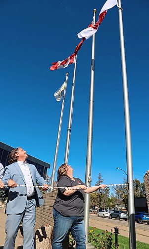 (From left) Mayor Jeff Fawcett and Cynamon Mychasiw, chief executive officer of United Way West Central Manitoba, raising a United Way flag at City Hall on Monday to commemorate the launch of the 2026 fall fundraising campaign. (Rylee Gerrard/The Brandon Sun)