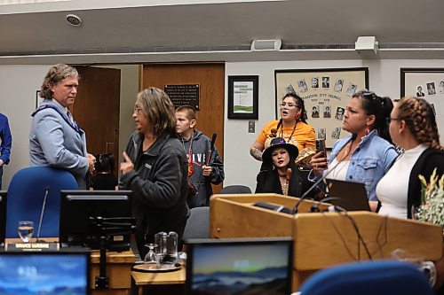 Brandon Mayor Jeff Fawcett (far left) is flanked by protesters after Monday’s city council meeting. (Alex Lambert/The Brandon Sun)