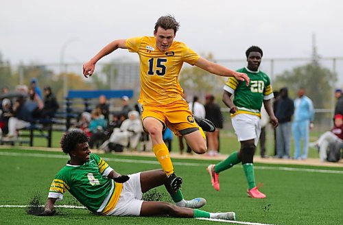 Assiniboine College's Mohamed Hassen slide tackles Brandon University's Declan Hoad. (Thomas Friesen/The Brandon Sun)