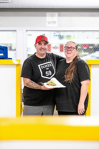 MIKAELA MACKENZIE / FREE PRESS
	
Josh and Amanda Darlington with their pickle smash burger at the Ile-des-Chenes Arena on Wednesday, Sept. 23, 2026.

For Dave Sanderson story.
Free Press 2026