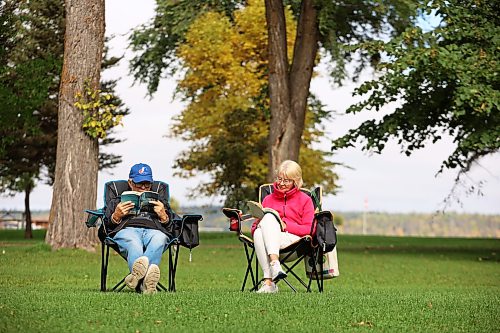 24092026
Tim and Barb Heppner of Winnipeg read in the park bordering Clear Lake in Wasagaming on a warm Thursday afternoon. 
(Tim Smith/The Brandon Sun)