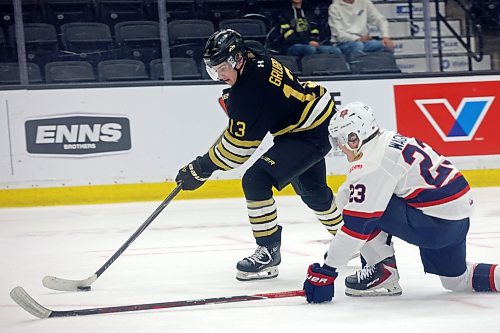 Wheat Kings Colin Grubb plays the puck past Aiden Wagner. (Tim Smith/The Brandon Sun)