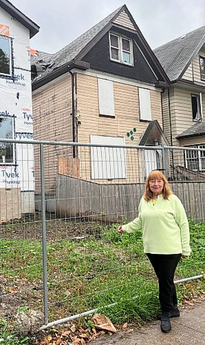 CAROL SANDERS / FREE PRESS

Linda Zak who lives doors down from 575 Furby St, right, and sees people coming and going from the boarded up house where there have been fires. Friday morning people were in the yard of the “vacant “ home calling out to people inside. 
