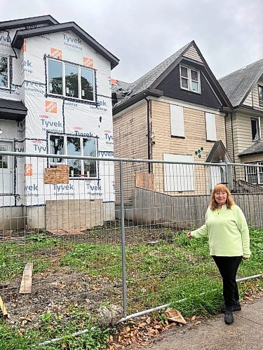 CAROL SANDERS / FREE PRESS 
Linda Zak who lives doors down from 575 Furby St, right, and sees people coming and going from the boarded up house where there have been fires. Friday morning people were in the yard of the “vacant “ home calling out to people inside.