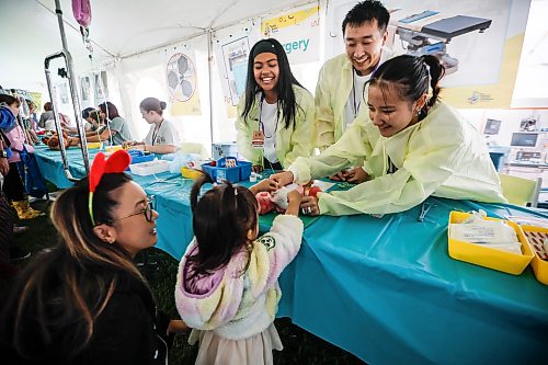JOHN WOODS / FREE PRESS
Volunteer nurses Jonessa Balaswit, from left, Danny Lam and Tammy Phan care for a stuffed toy for Nicole Mendoza and her daughter Maya at the Teddy Bear Picnic at Assiniboine Park in Winnipeg, Sunday, September 27, 2026. 

reporter: standup
