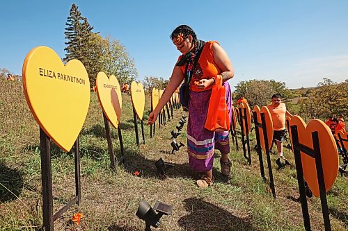 Nancy McGillivary of Opaskwayak Cree Nation makes offerings at the markers for children who died while forced to attend the Brandon Indian Residential School during the 2025 Truth and Reconciliation Week Orange Shirt Day Walk. (Tim Smith/The Brandon Sun files)