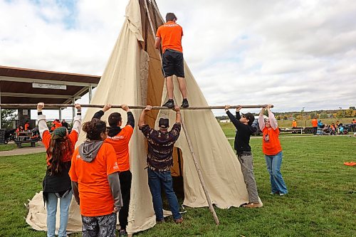 Austin Switzer with Assiniboine College’s public safety program is held up as volunteers take part in the teepee raising and teachings event on the first day of Truth and Reconciliation Week 2026 at the Brandon Riverbank Discovery Centre grounds on Monday. (Tim Smith/The Brandon Sun)
