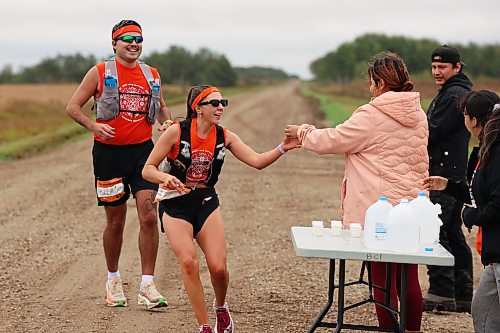 Dylan Peyachew and Reann Hucaluk of Winnipeg grab water from volunteers while taking part in the fifth annual Reconciliation Run half marathon from the former Birtle Residential School site to Birdtail Sioux First Nation on Saturday. (Tim Smith/The Brandon Sun)